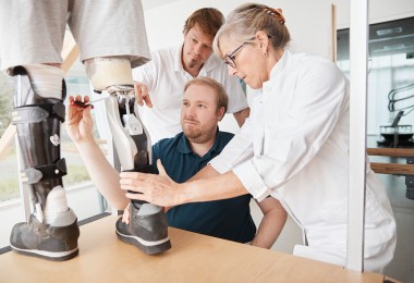 Ärztliches Personal passt bei einem Patienten eine Prothese des Unterschenkels an. Ärztliches Personal passt bei einem Patienten eine Prothese des Unterschenkels an.